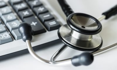 Closeup of a calculator and a stethoscope healthcare and expenses concept